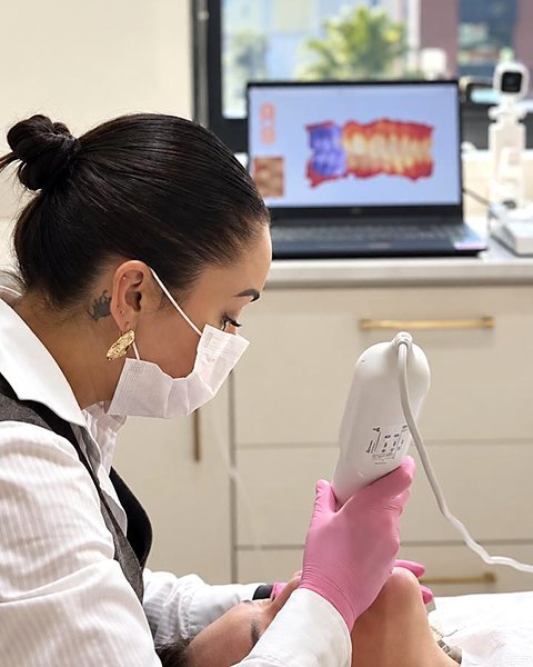 Dra. Alícia Pinheiro Gomes fazendo o escaneamento digital com o iTero, com o sorriso em 3D na tela